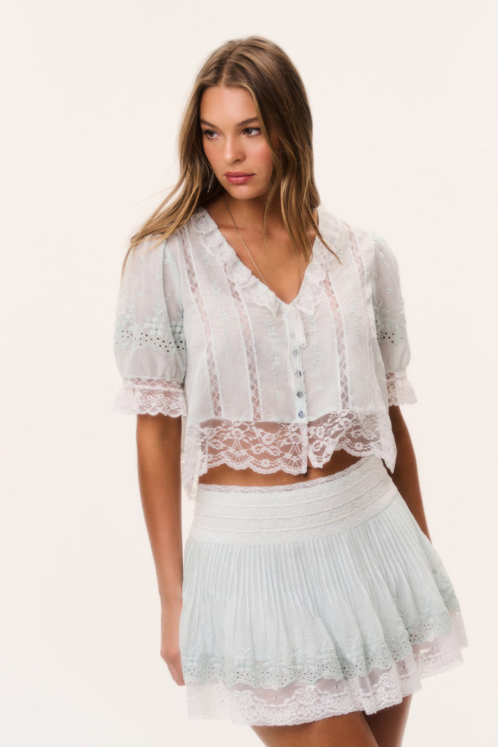 Ivory mini skirt with lace-trimmed tiered ruffles and smocked elastic waist