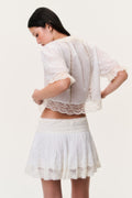Back view of ivory mini skirt with lace hem and tiered ruffle layers