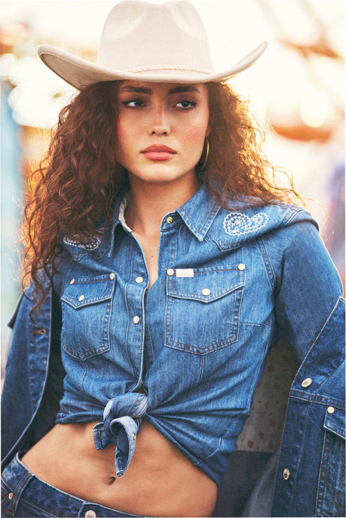 Denim western snap shirt with chest pockets, embroidered yoke, and tied front hem