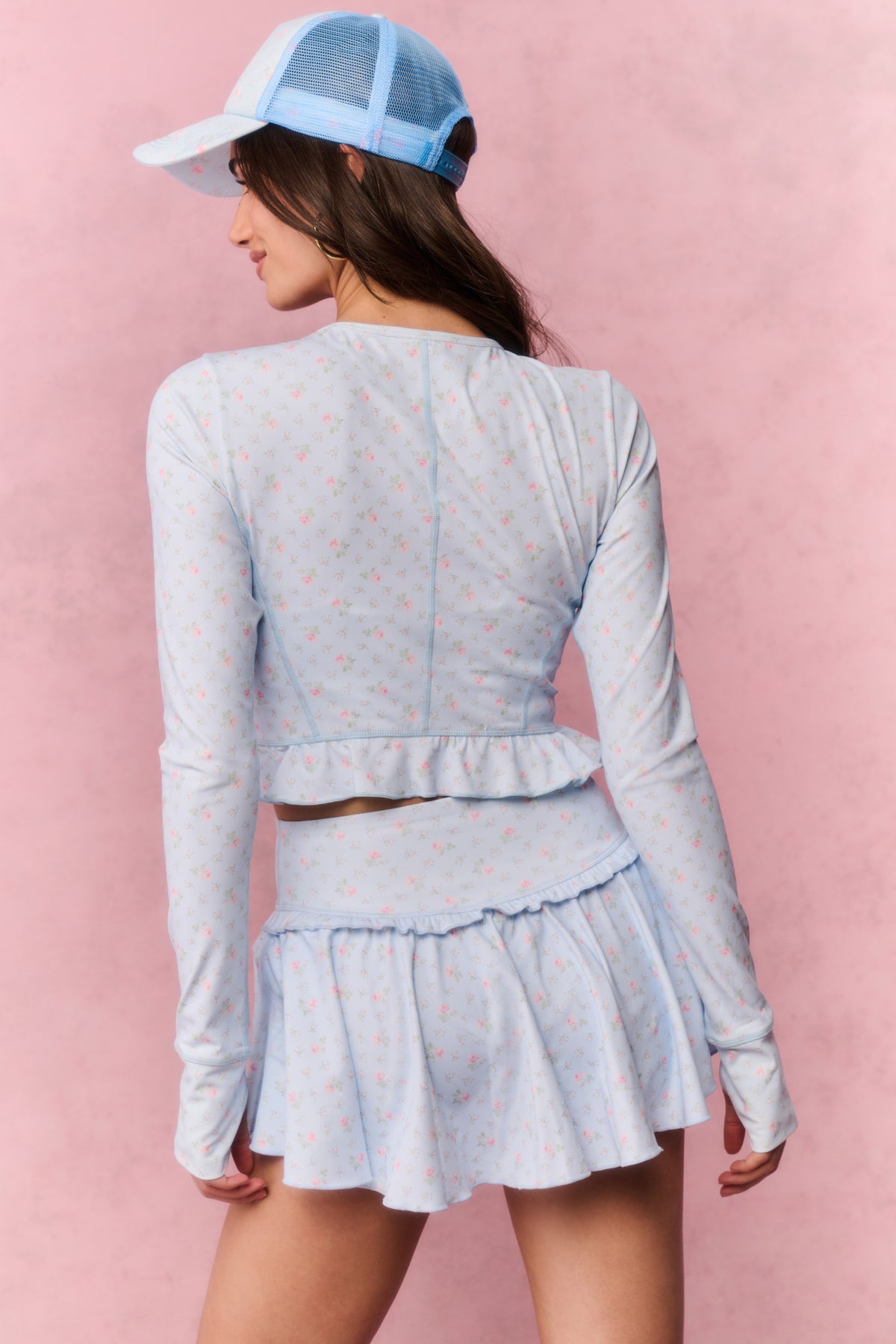 Light blue printed zip-up active top, long sleeves, open back, and ruffled peplum hem