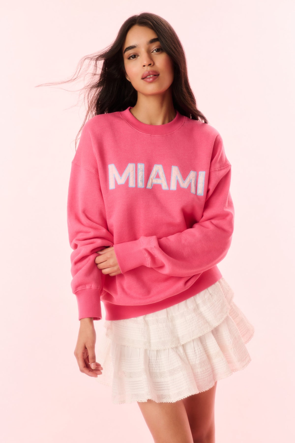 Pink pullover sweatshirt with MIAMI graphic on chest and ribbed cuffs