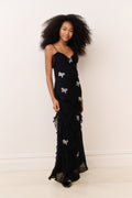 Black sleeveless mini dress with layered ruffle panels and bow appliques