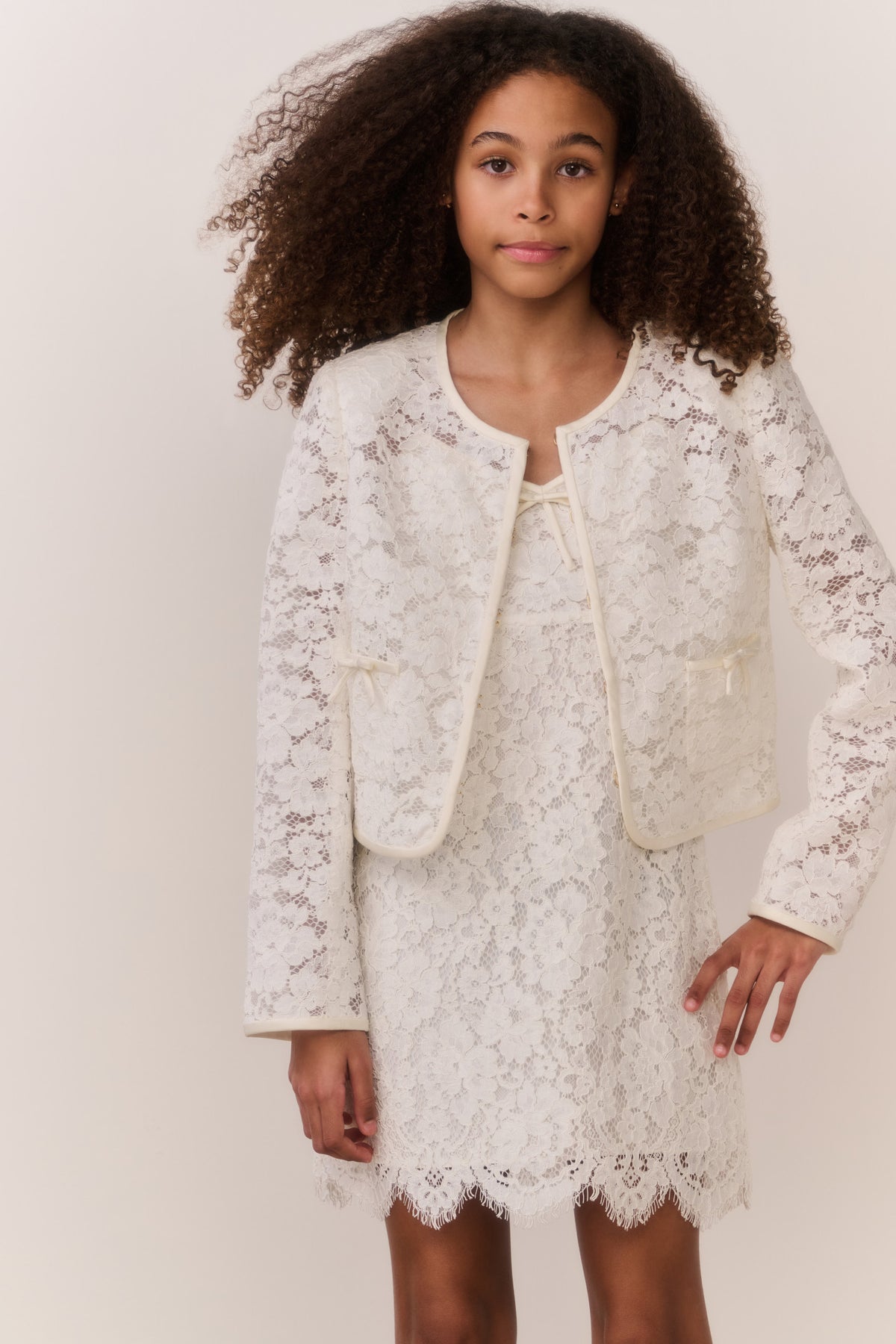 Ivory lace jacket worn over lace dress, long sleeves and button front