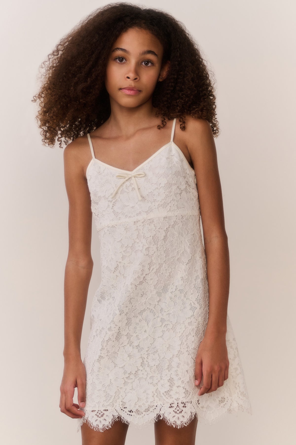 Ivory lace mini dress with floral lace texture, thin straps and scalloped hem