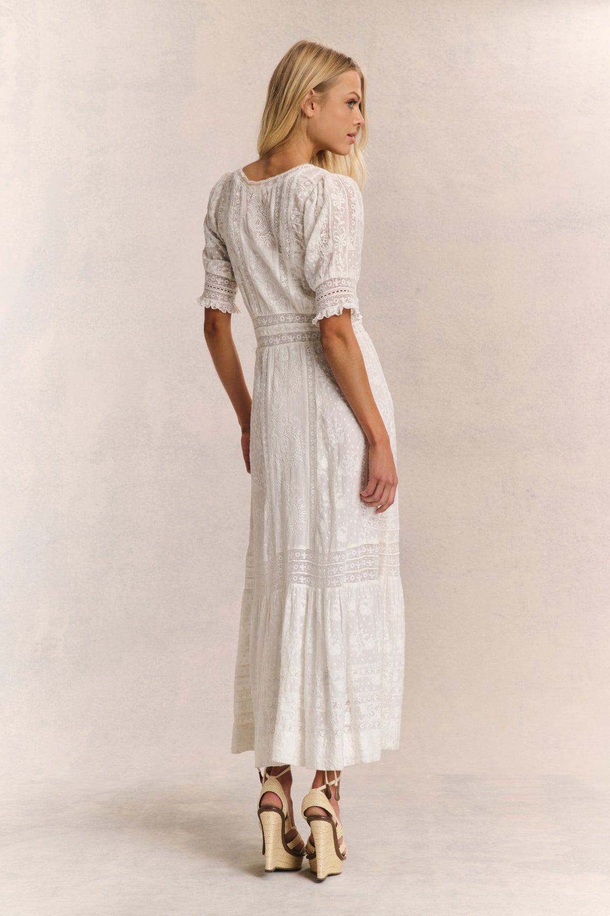 White maxi dress with lace-look texture and tiered skirt, back/side view