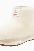 Off-white girls boot with faux-fur upper, stitched side seam, and light sole