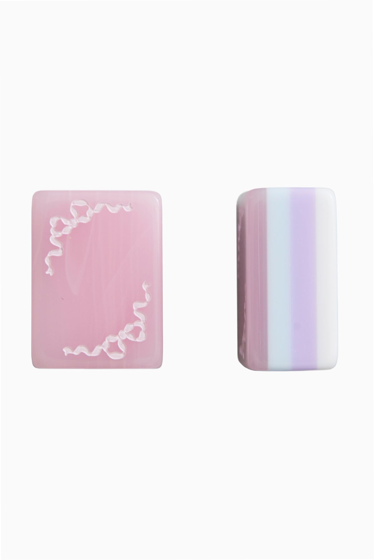 Two pastel mahjong tiles: pink face with lace border and striped side