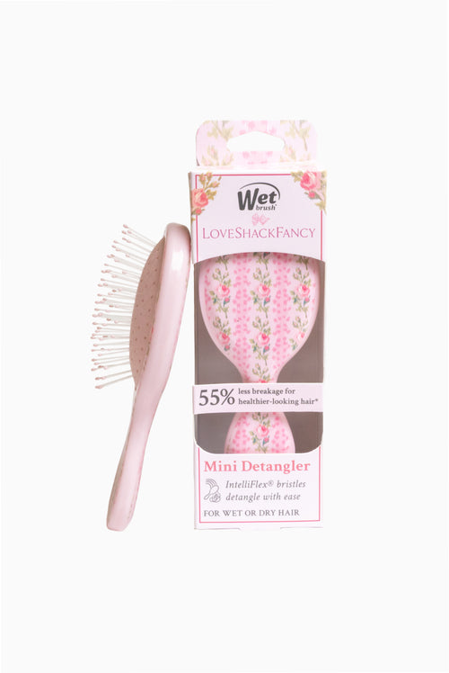 Mini detangling hair brush in pink floral, next to retail box