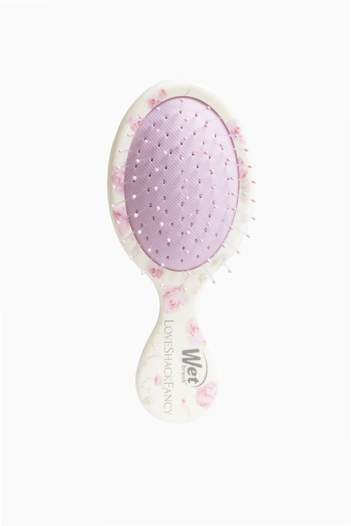 Mini detangler hair brush with oval head, light purple pad, and rose-printed border