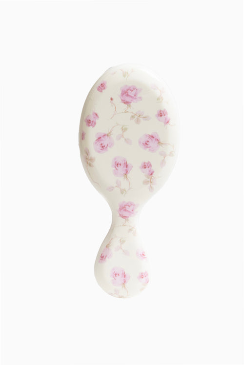 Mini detangler hair brush with pink rose floral print on white brush head and handle