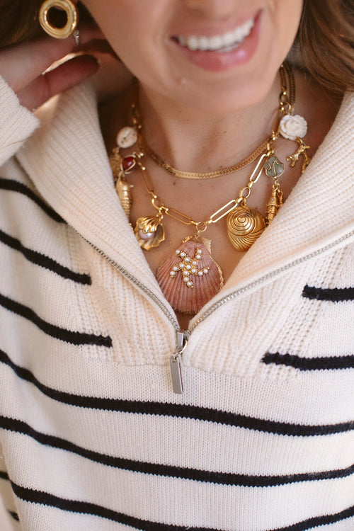 Gold-tone shell charm necklace with dangling shell pendants, layered look