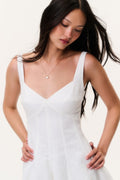 White linen mini dress bodice close-up with V neckline and spaghetti straps