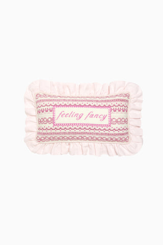 Pink and white decorative needlepoint pillow with ruffled edge and “Feeling fancy”