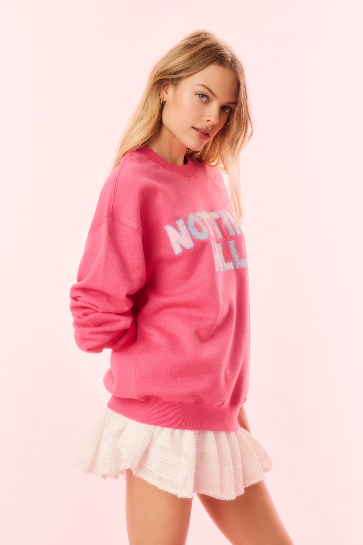 Pink pullover sweatshirt with partial 'NOTTING HILL' logo (front)