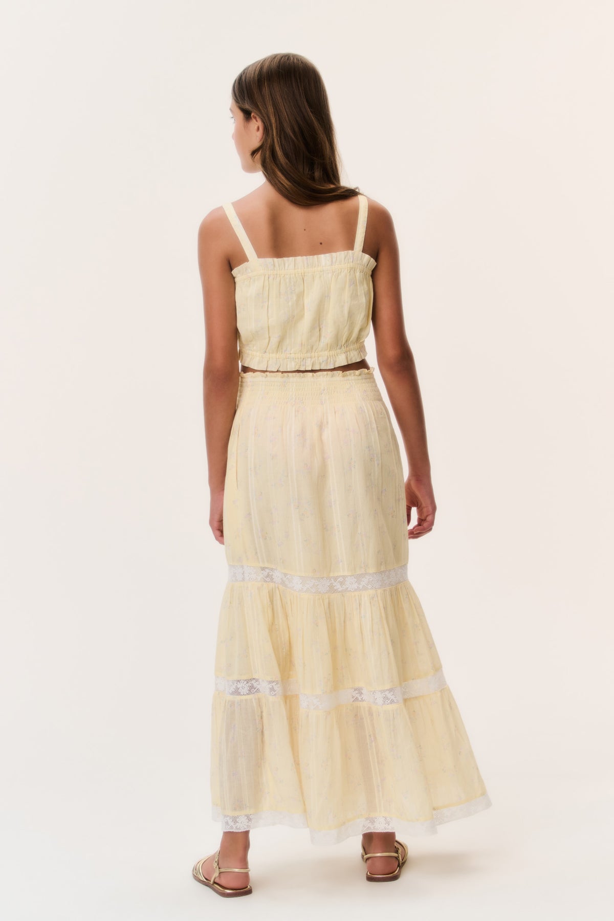 Light yellow tiered tween skirt with lace-trim bands, back view