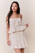 Floral embroidered cotton mini skirt with tiered ruffles and gathered waist (front, three-quarter).