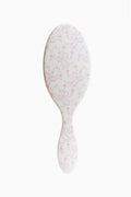 Pink floral detangling hair brush with oval paddle shape and bristle surface