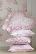 Heart-shaped ruffle pillow in light pink with allover floral print