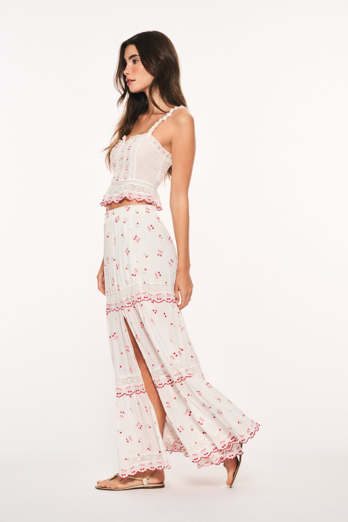 Optic white cotton maxi skirt with red cherry print, tiered ruffles, and side slit