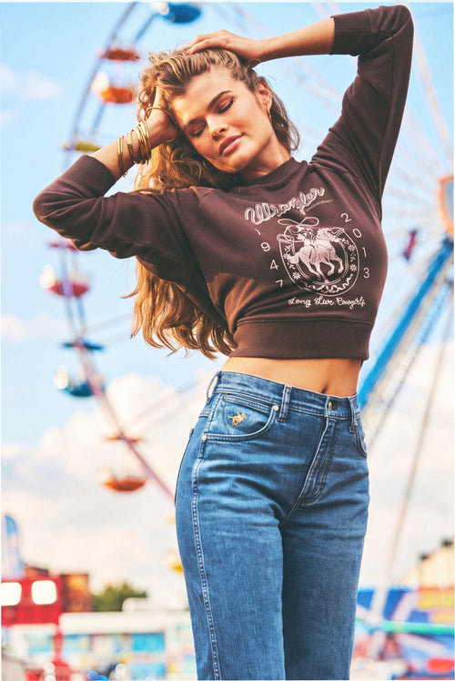 Burgundy sweatshirt with front horseshoe graphic, model wearing it with jeans