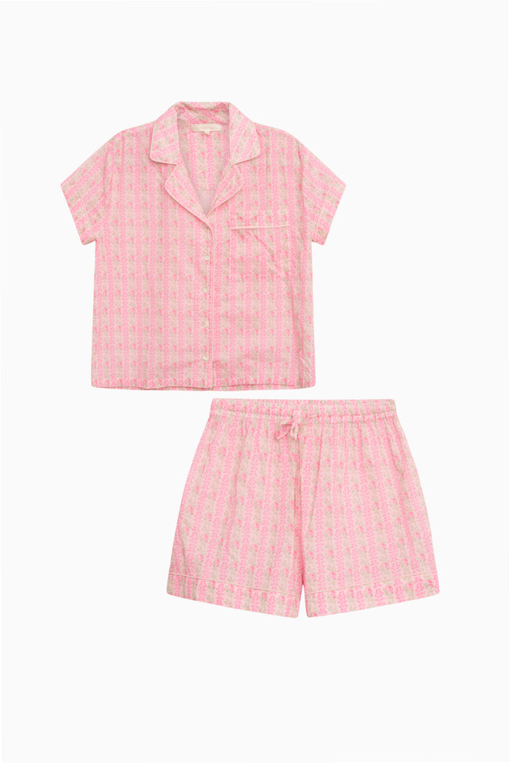 Pink cotton pajama set flat lay: short-sleeve button-up top and matching shorts