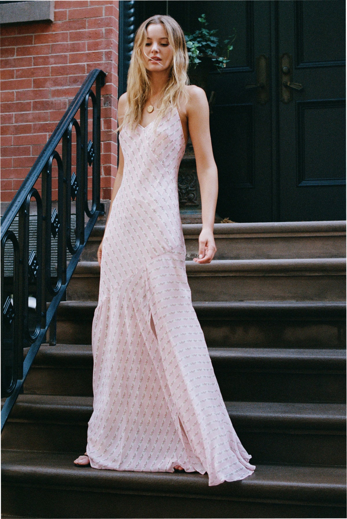 Light pink maxi dress with spaghetti straps, V-neck, and side slit, patterned fabric.