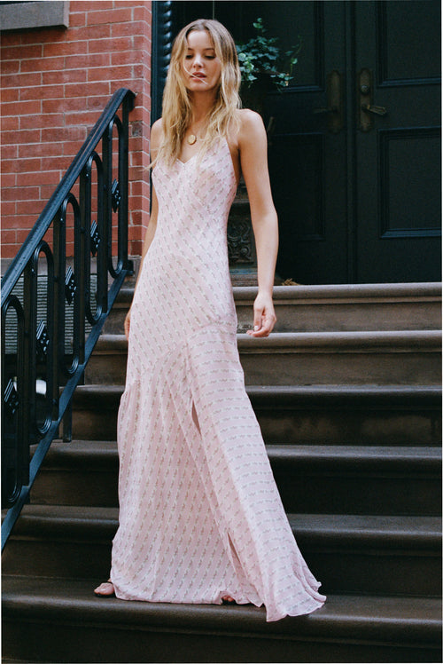 Light pink maxi dress with spaghetti straps, V-neck, and side slit, patterned fabric.