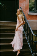 Light pink maxi dress side view with spaghetti straps, V-neck, and flowing drape.