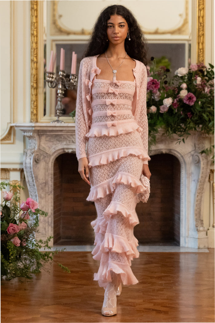 Pink knit tiered ruffle dress with lace texture, bow accents, and thin shoulder straps