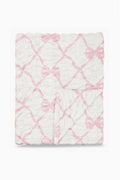 Folded fleece-style blanket with pink bow lattice pattern on white background