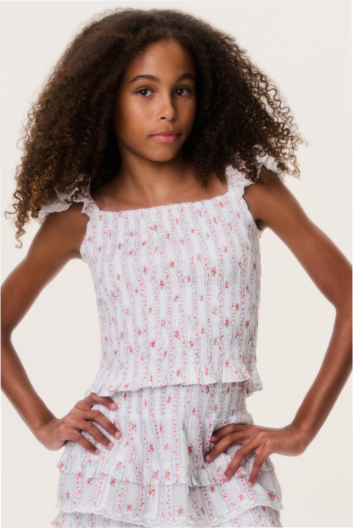 Girls' sleeveless white top with red print, ruffled shoulders and tiered hem.