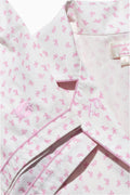 Pink bow-print pajama fabric detail with collar and button placket