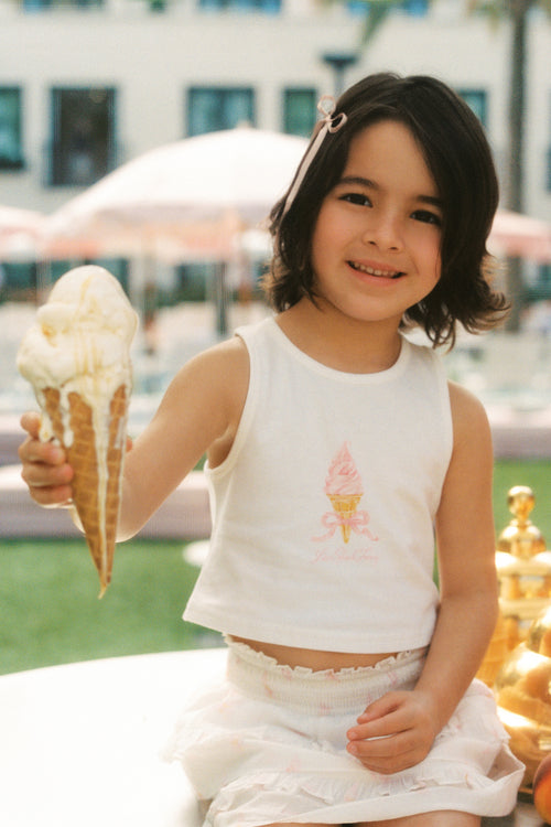 Girls' sleeveless vanilla tank top with pink tree graphic, close-up