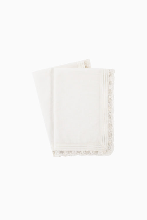 Set of 4 white cloth napkins with scalloped lace borders, stacked
