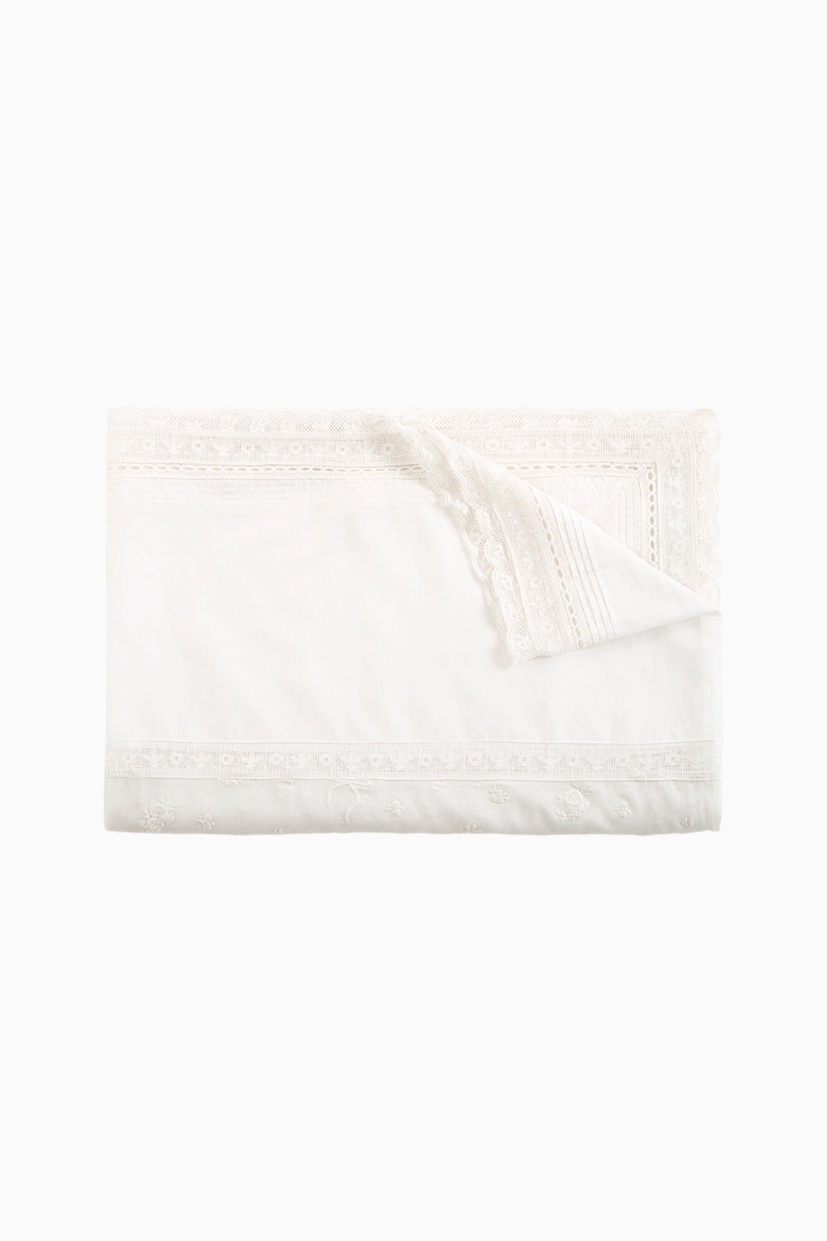 Folded white table linen napkin with lace border and scalloped trim