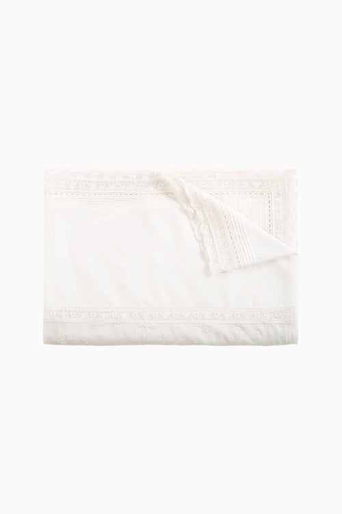 Folded white table linen napkin with lace border and scalloped trim