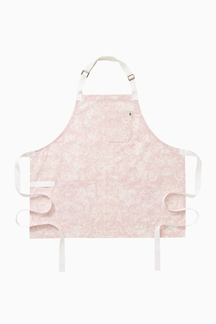 Perennial pink printed apron, front flat lay with adjustable straps and ties