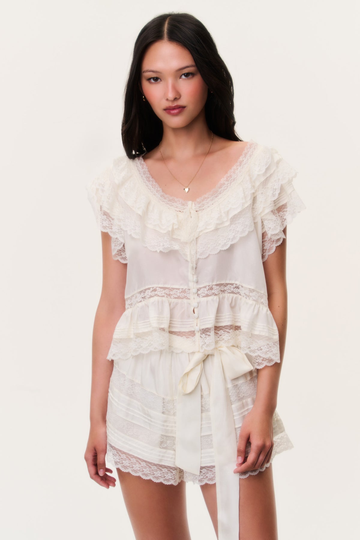 Ivory silk ruffle top with off-shoulder neckline and tiered lace trims, drawstring waist