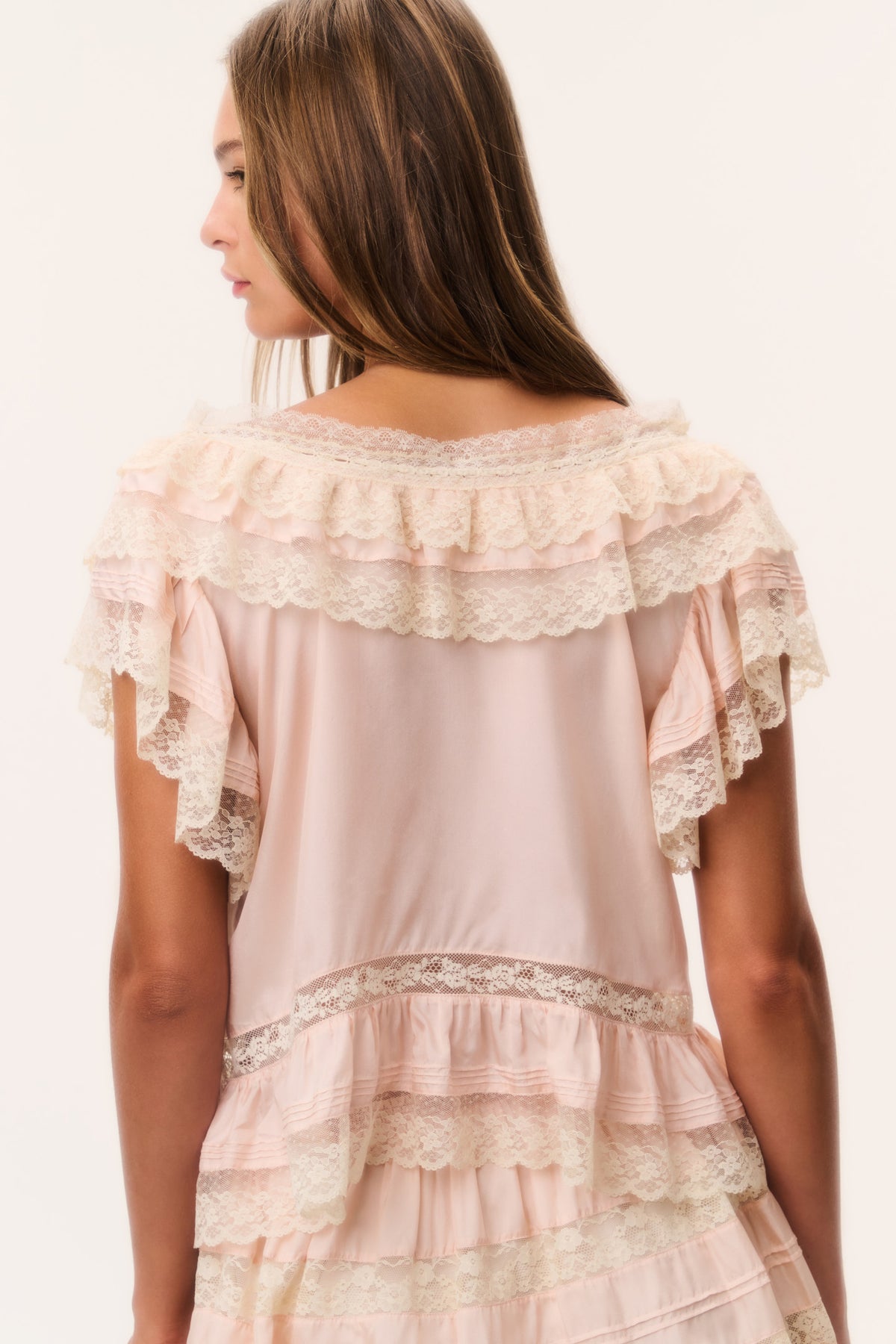 Petal peach silk ruffle top back view with lace shoulder ruffles and tiered hem detail