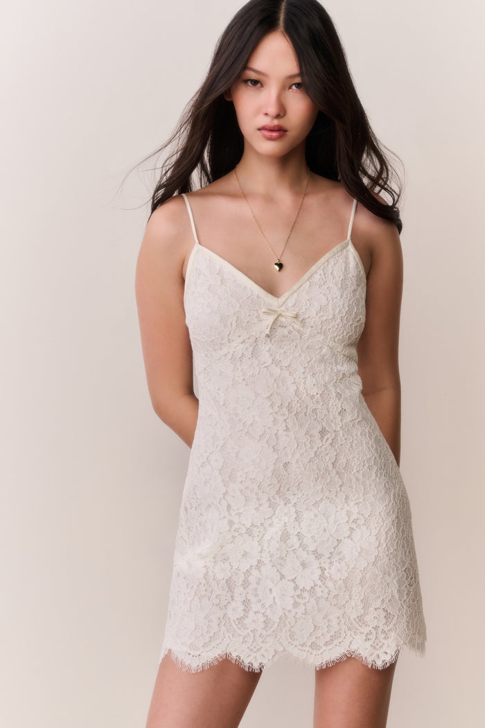Ivory lace mini dress on model, spaghetti straps and lace V-neck bodice