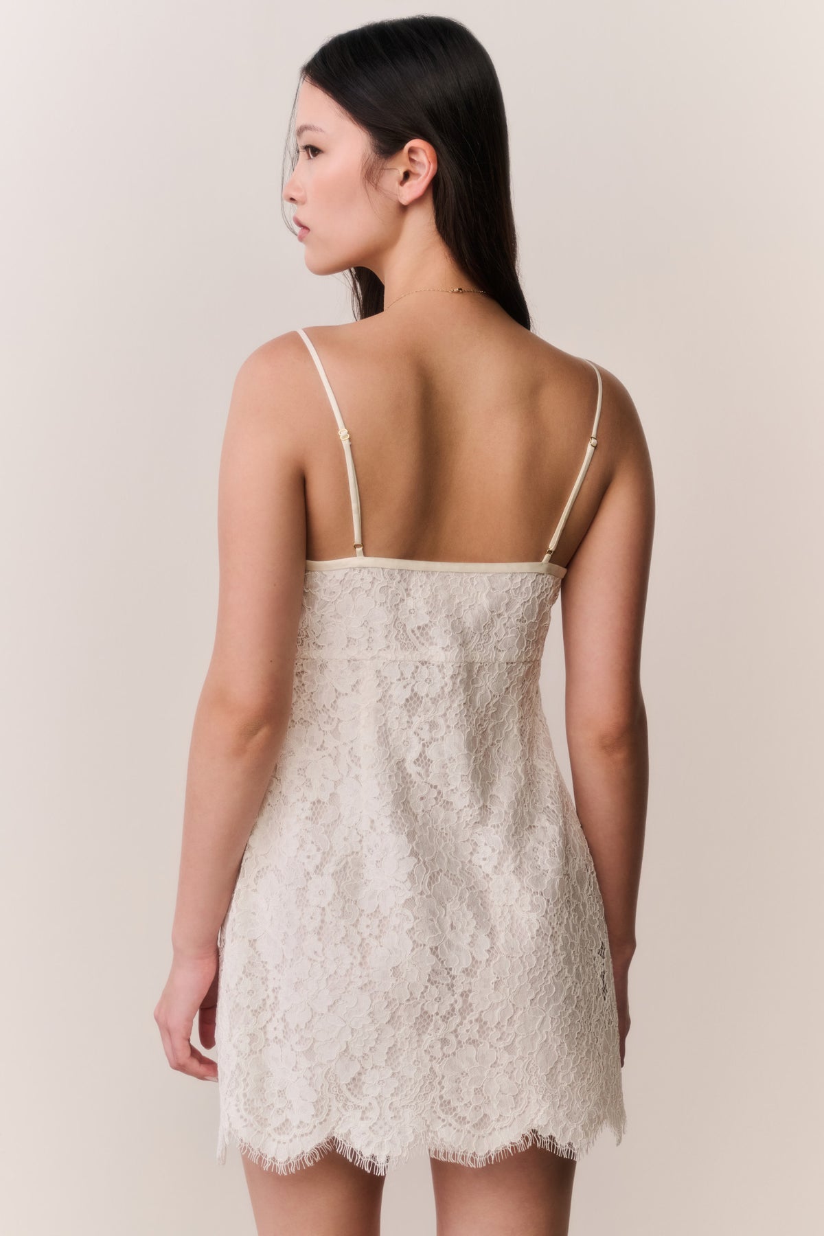 Ivory lace mini dress, back view with spaghetti straps and scalloped hem