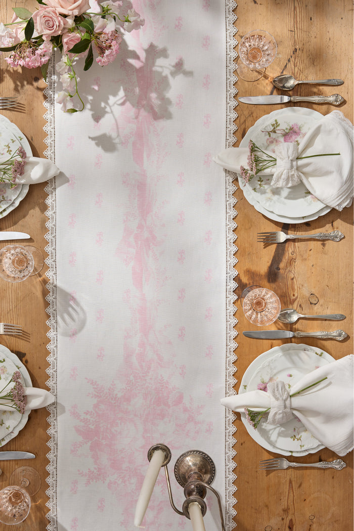 Pink printed table runner with Victorian floral pattern and lace scalloped edges