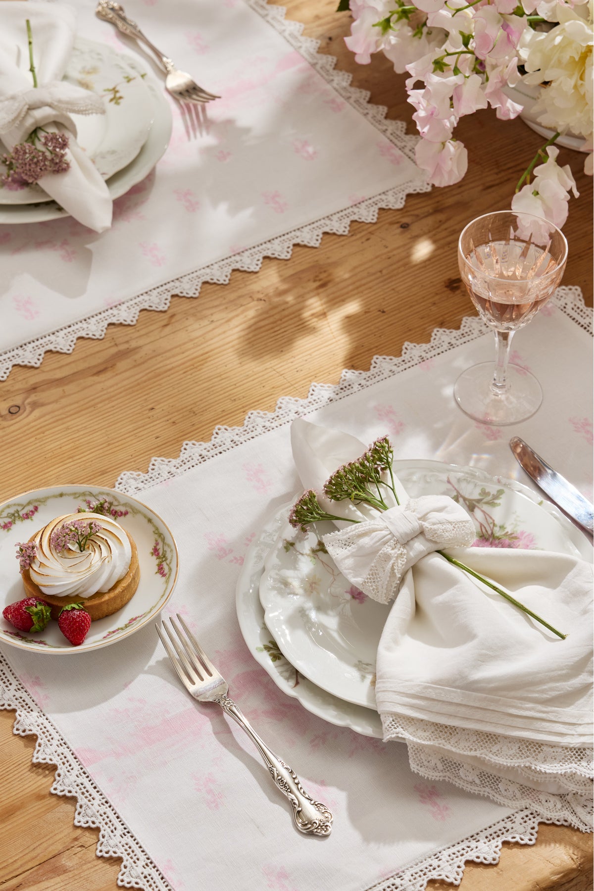 Pink place mat with scalloped lace trim and small Victorian-style floral print