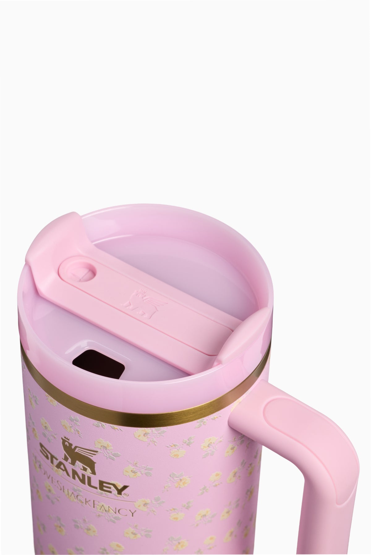 Pink tumbler lid with slide opening and flip spout; gold rim and handle visible