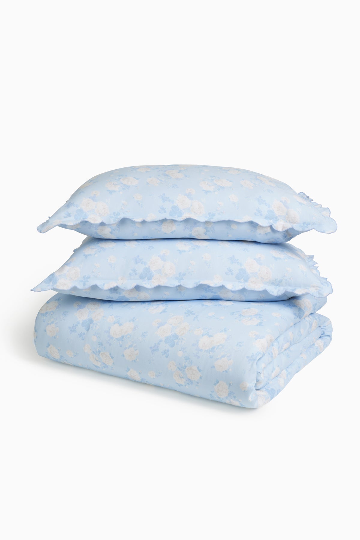 Light blue printed duvet cover and sham set, folded with matching ruffled shams