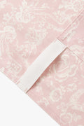 Close-up of pink apron panel with white contrast binding along diagonal edge