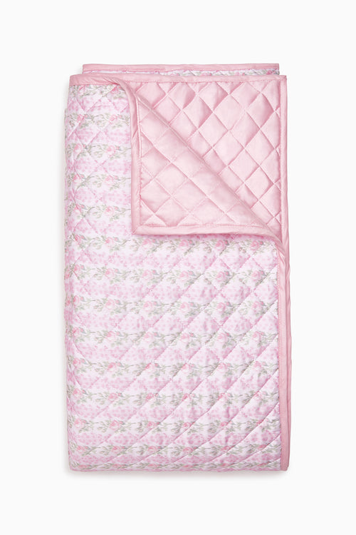 Pink floral quilt with diamond stitched pattern and ruffled border edges
