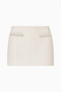 Ivory tweed mini skirt with two front slit pockets and fringe trim