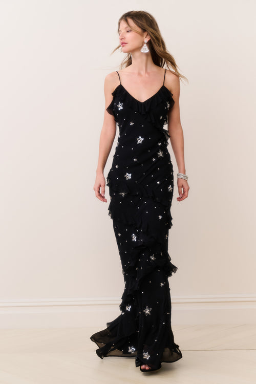 Black sleeveless maxi dress with V-neck, star crystal embellishments, and layered ruffle hem.