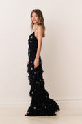 Black maxi dress with star-crystal embellishment, spaghetti straps, and tiered skirt detail.